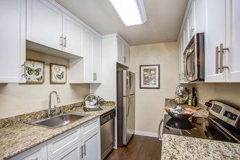 a kitchen with granite counter tops and stainless steel appliances at Valley Plaza Villages, Pleasanton, California